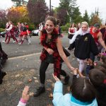 Snohomish High School students slap hands with Central Elementary students during the annual Serpentine Parade on Friday. (Andy Bronson / The Herald)