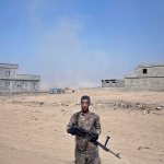 An Iraqi army soldier stands next to a dead body of an Islamic State fighter on the outskirts of Qayyarah, Iraq, on Wednesday, Oct. 19. A senior Iraqi general on Wednesday called on Iraqis fighting for the Islamic State group in Mosul to surrender as a wide-scale operation to retake the militant-held city entered its third day. (AP Photo/Marko Drobnjakovic)