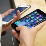 In this Sept. 16 photo, Lisa Gao, from Chicago, compares a new jet black iPhone 7, right, with her iPhone 6 at an Apple Store in Chicago. (AP Photo/Kiichiro Sato, File)