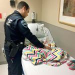 Officer Andrew Lindgren comforts the little girl rescued from a homeless camp in Auburn. (Auburn Police Dept.)