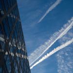 Airplane contrails are reflected in a building as they cross the early morning sky above Pennsylvania Avenue in Washington in 2015. (AP Photo/Carolyn Kaster)
