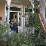 Sharon Kelsey, front, and her cousin, Pamela Williams, stand on the front port of the Victorian home in Savannah, Georgia, where Kelsey lives in a first floor apartment, on Monday. A large tree crashed across the front of the house as Hurricane Matthew raked the Georgia coast over the weekend. Matthew did extensive damage to the signature tree canopy in Savannah. (AP Photo/Russ Bynum)