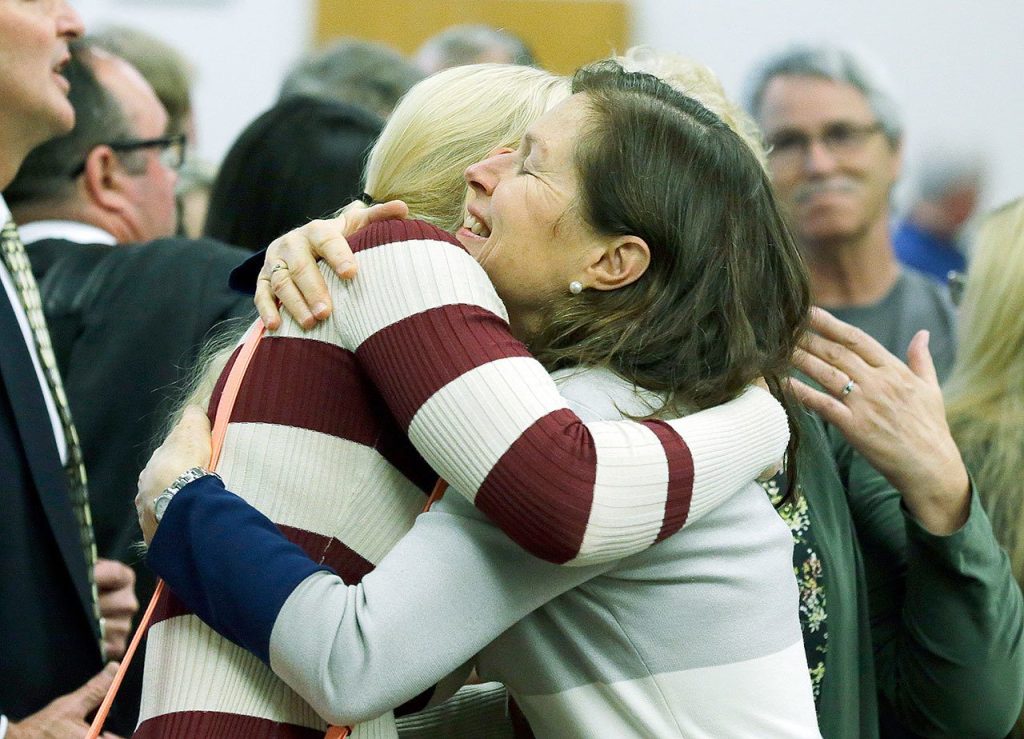 In King County Superior Court in Seattle, Corrie Yackulic (right), an attorney representing several family members of victims of the 2014 Oso mudslide, hugs Lisa Bevjl, who lost her brother, Alan, in the slide. (AP Photo/Ted S. Warren)