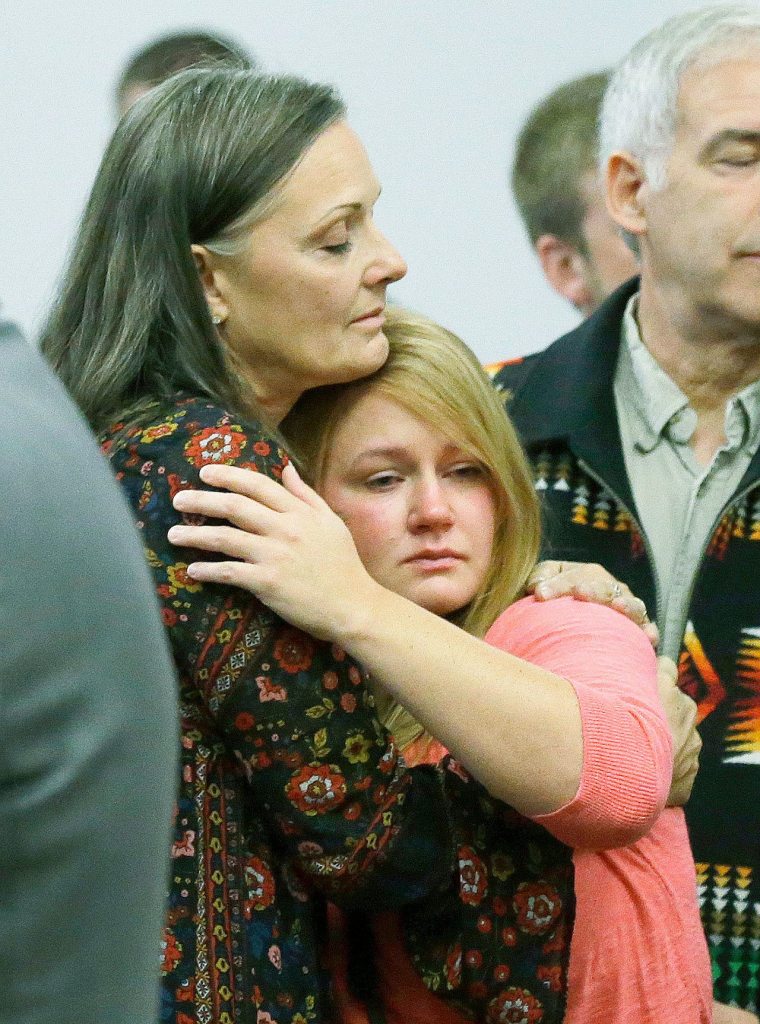 Family members of victims of the 2014 Oso landslide, including Deborah Farnes (left) and Jonielle Spillers, react in King County Superior Court on Monday in Seattle after the announcement that a settlement had been reached in a lawsuit brought by survivors and family members of the 43 people killed. (AP Photo/Ted S. Warren)