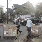 People evacuate children in the area of Northwest 23rd Avenue and Glisan Street after a gas explosion Wednesday, Oct. 19, in Portland, Oregon. (Stephanie Yao Long/The Oregonian via AP)