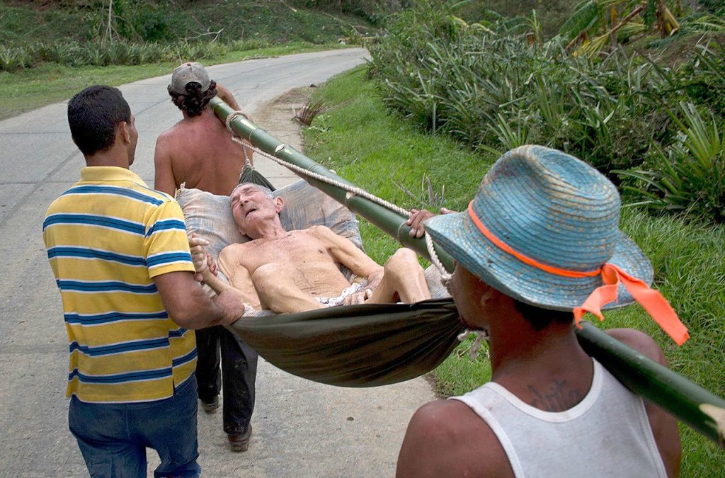 An elderly man who was in a hospital before Hurricane Matthew hit is carried home on a hammock in Baracoa, Cuba, on Thursday. He was carried on foot because the roads are impassable due to storm damage. (AP Photo/Ramon Espinosa)