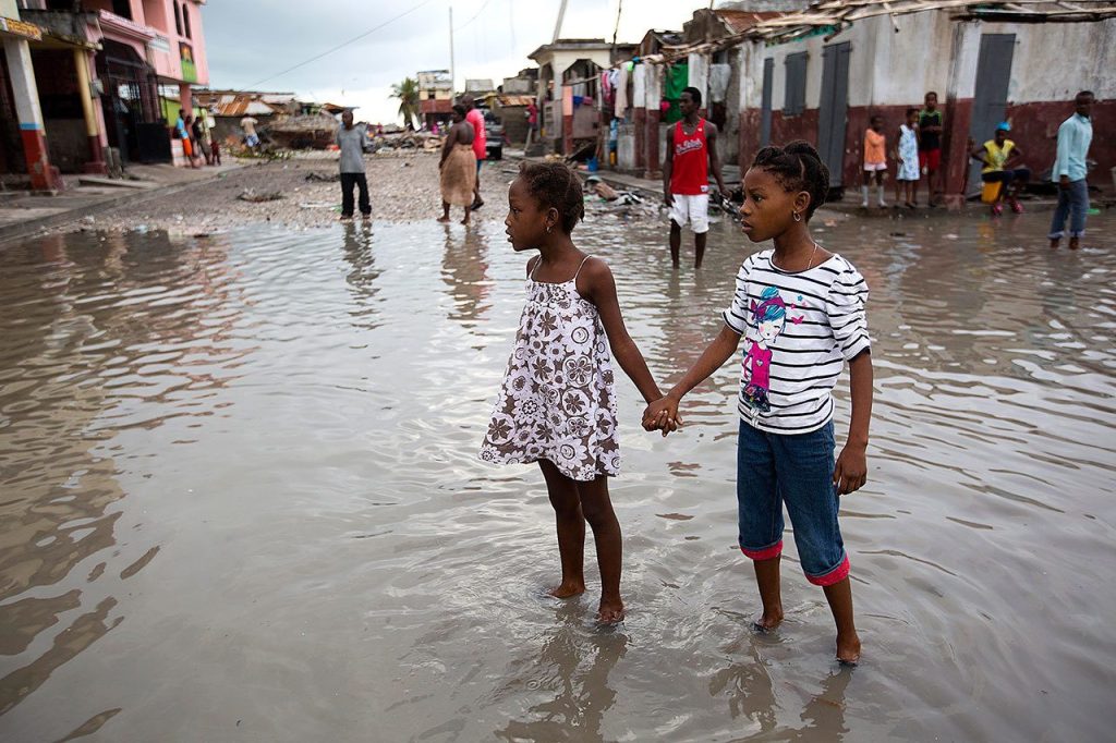 Girls hold hands as they help each other wade through a flooded street after the passing of Hurricane Matthew in Les Cayes, Haiti, on Thursday. (AP Photo/Dieu Nalio Chery)