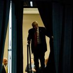 Donald Trump walks through the curtains at a campaign rally at the South Florida Fairgrounds and Convention Center on Thursday. (AP Photo/ Evan Vucci)