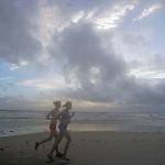 A pair of joggers run before sunrise along the surf of the Atlantic ocean Thursday in Daytona Beach, Florida. Forecasters said the first outer rain bands from Hurricane Matthew already have begun to approach Florida as the big storm crosses the Bahamas toward the state. (AP Photo/Chris O&rsquo;Meara)