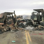 The burned hulks of heavy trucks sit on Highway 1806 near Cannon Ball, North Dakota, on Friday, Oct. 28, near the spot where protesters of the Dakota Access pipeline were evicted from private property a day earlier. Authorities say protesters burned several pieces of construction equipment Thursday during a chaotic confrontation with law enforcement. (AP Photo/James MacPherson)