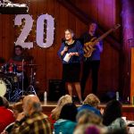 MaryEllen Wood gets on stage with the band to welcome a packed house, Wednesday night at the Interfaith Association&rsquo;s fundraiser at Floral Hall in Forest Park. (Dan Bates / The Herald)
