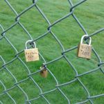 Padlocks hang on the fence that surrounds Stanwood High School with names scrawled on them of students who died by suicide in 2015. Three deaths in one year shook the tight-knit community into action to try and prevent more suicides. (Kari Bray/Herald writer)