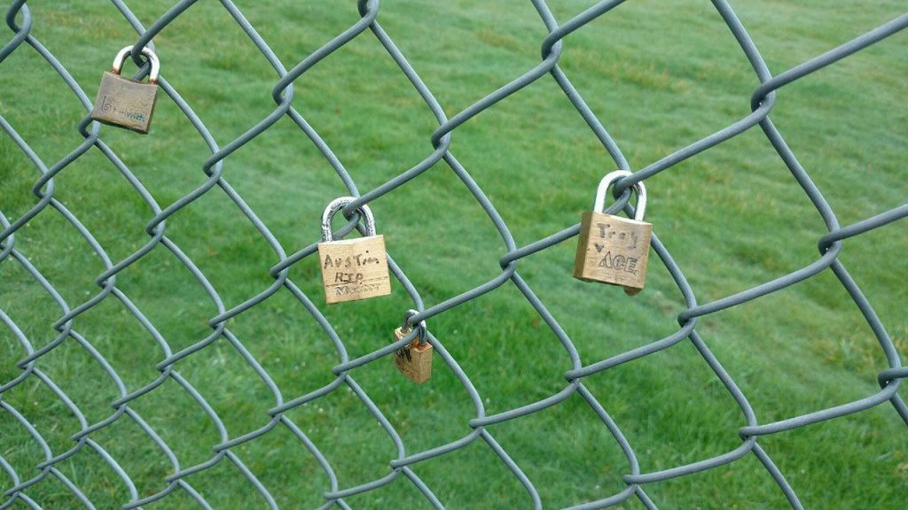 Padlocks hang on the fence that surrounds Stanwood High School with names scrawled on them of students who died by suicide in 2015. Three deaths in one year shook the tight-knit community into action to try and prevent more suicides. (Kari Bray/Herald writer)