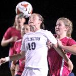 Arlington&rsquo;s Courtney Arnold heads the ball with Meadowdale&rsquo;s Sarah Elder defending in the first half of play Thursday night at John Larson Stadium in Artlington on October 6, 2016. (Kevin Clark / The Herald)