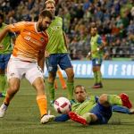 The Sounders&rsquo; Tony Alfaro makes a slide tackle to disrupt the Dynamo&rsquo;s Will Bruin in the first half Wednesday night at Century Link Field in Seattle. (Kevin Clark / The Herald)