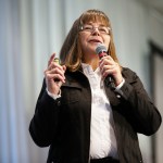 Jan Steves speaks at the 11th annual Domestic Violence Services of Snohomish County luncheon at Xfinity Arena in Everett on Wednesday. Steves, originally from Edmonds, now lives in Alaska and ran her first Iditarod sled dog race in 2012. (Ian Terry / The Herald)