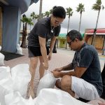 Miroslava Roznovjakova, left, and Ray Hayyat place sandbags in front of their store to guard against flooding Thursday in Daytona Beach, Florida. Hurricane Matthew continues to churn its way toward Florida&rsquo;s east coast. (AP Photo/Chris O&rsquo;Meara)