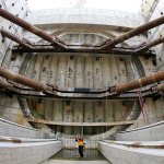 In this photo made with a fish-eye lens, reporters and photographers stand in the pit where a tunnel-boring machine known as &ldquo;Bertha&rdquo; will emerge when the nearly 2-mile tunnel of the Highway 99 project to replace the earthquake-damaged Alaskan Way Viaduct is completed during a media tour Monday in Seattle. (AP Photo/Ted S. Warren)
