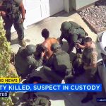 In this still frame from video, Los Angeles County Sheriff&rsquo;s deputies take into custody a wounded man, who is a suspect in the shooting death of a deputy, in Lancaster, California, on Wednesday. (KABC-TV via AP)