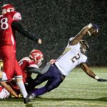 Oak Harbor&rsquo;s Princeton Lollar reaches for extra yardage with Marysville Pilchuck defenders hanging on during a game Thursday at Quil Ceda Stadium in Marysville. (Kevin Clark / The Herald)