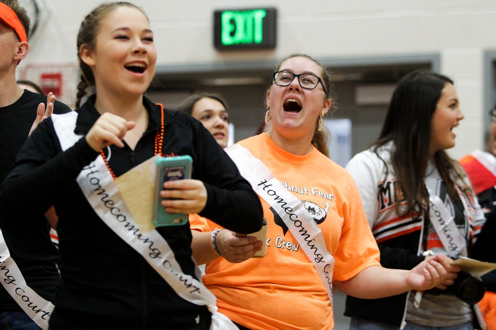 Monroe High School homecoming nominees Jada Castor (left), from the dance team, and Ashley Donaldson, from the link crew club that helps incoming freshmen, dance and cheer during an assembly at the school on Friday morning. (Ian Terry / The Herald)