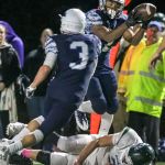 Meadowdale&rsquo;s Jashon Butler intercepts a pass intended for Edmonds-Woodway&rsquo;s Henry Tillman (bottom) with Meadowdale&rsquo;s Will Schafer looking on during a game Friday at Edmonds Stadium. (Kevin Clark / The Herald)