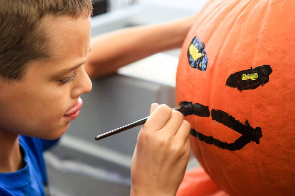Kavan Dunbar, 9, paints his pumpkins Saturday morning at Fred Meyer in Monroe. (Kevin Clark / The Herald)