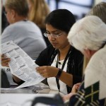 Workers examine ballots at the Snohomish County ballot return center in Mukilteo on Thursday. (Ian Terry / The Herald)