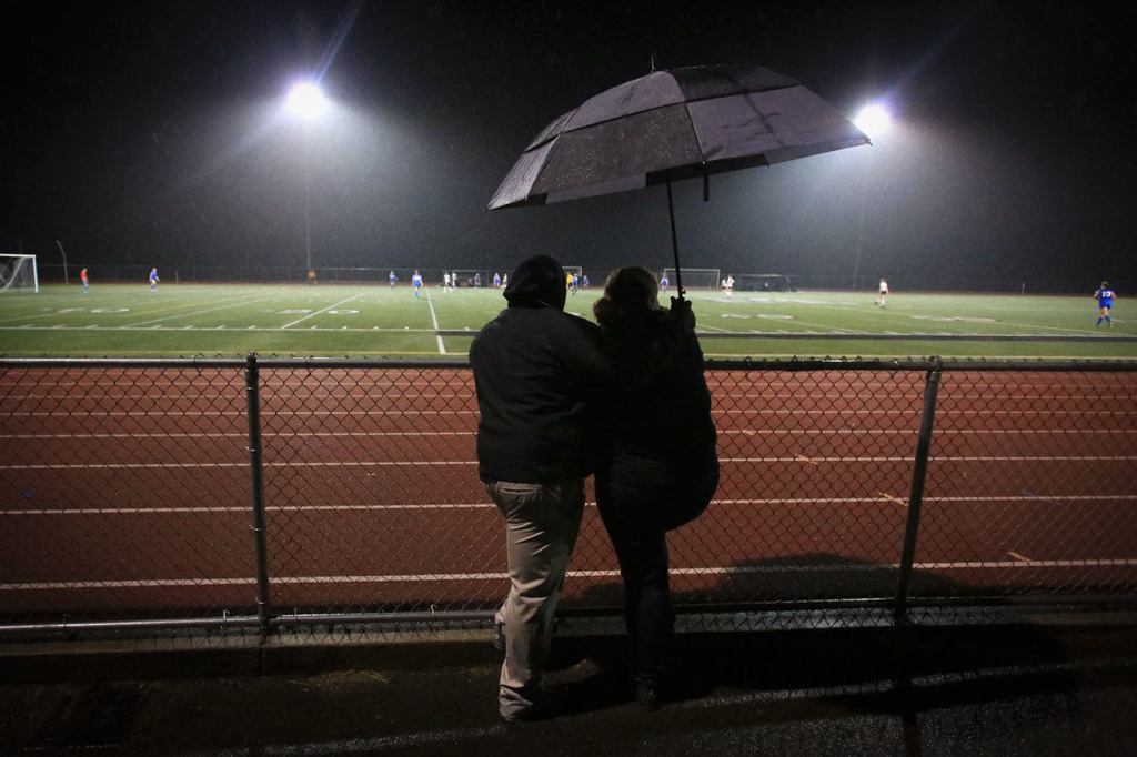 Steve and Sabrie Taylor brave the elements to watch their daughters, Oshinaye and Veronika Taylor, play soccer for Marysville Getchell High School. The couple has been together 18 years and raised three children. Their oldest son, DeJohn Ward, died by suicide last year. (Kevin Clark/The Herald)