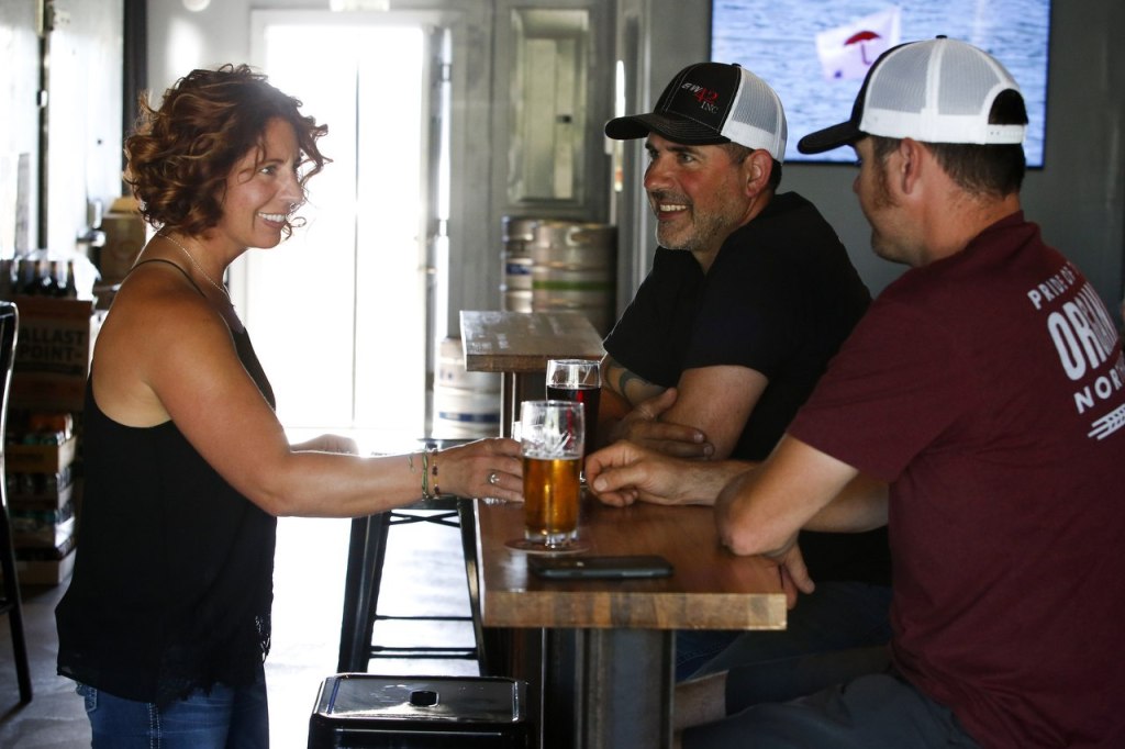 &mdash; Bartender Peri-Lyn Johnson (left) chats with Ryan Gagnon and Dan Misich . Gagnon and Misich custom built and installed all of the shelves, tables and the bar at the newly opened bottleshop. (Ian Terry / The Herald)