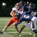 Stanwood&rsquo;s Trygve DeBoer is gang tackled by the Arlington defense during the annual Stilly Cup football game Friday night in Arlington. (Kevin Clark / The Herald)