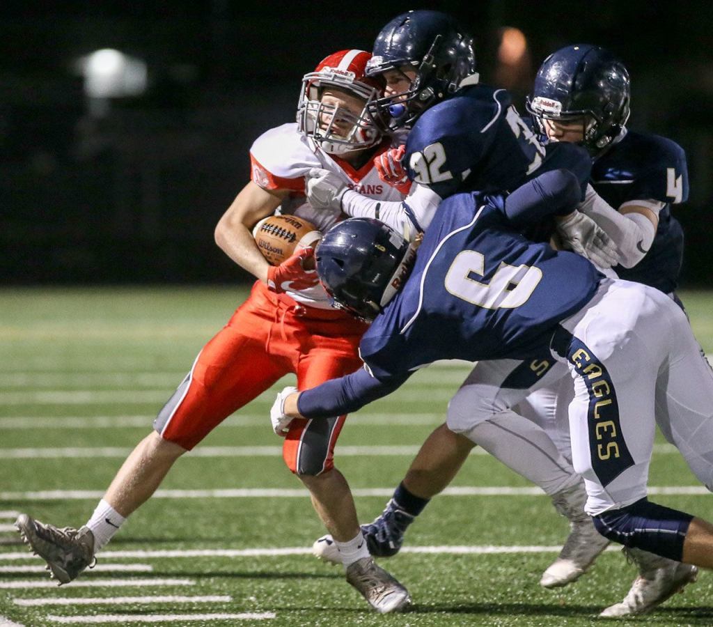 Stanwood&rsquo;s Trygve DeBoer is gang tackled by the Arlington defense during the annual Stilly Cup football game Friday night in Arlington. (Kevin Clark / The Herald)