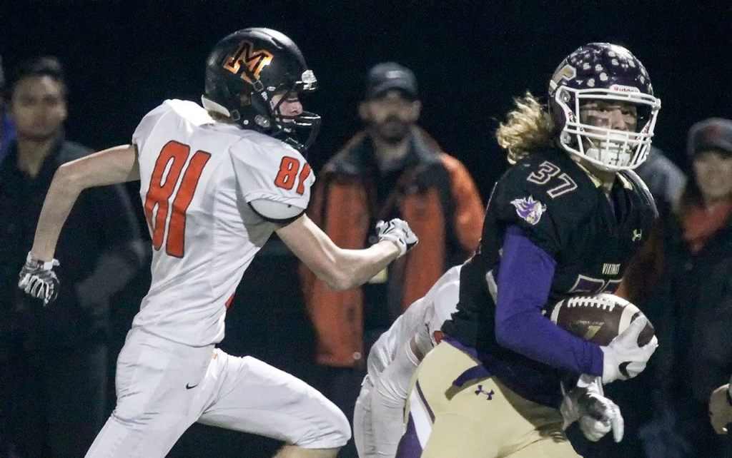 Lake Stevens&rsquo; Hunter Eckstrom runs for the end zone with Monroe&rsquo;s Skyler Barr trailing during a game Friday at Lake Stevens High School. (Kevin Clark / The Herald)
