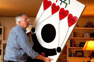 At his home in Everett Thursday, Chris Hoiby moves a door-full of reasons to celebrate the 30th anniversary of the Snohomish County Children&rsquo;s Commission in preparation for next week&rsquo;s event, which will honor past and present volunteers. (Dan Bates / The Herald)