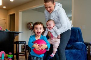 Carrying 4-month-old Haven, Apryl Roberts chases 2-year old Charlee around the house Wednesday, to the delight of all three. (Dan Bates / The Herald)