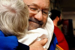 Frank Fargo, who offers free showers out of his trailer, is among 2016 KSER Voice of the Community Award winners. He is shown here in 2012 getting a hug from Lois Sugars at Everett&rsquo;s First Presbyterian Church, where he provides showers during a weekly dinner for people who are homeless. (Sarah Weiser / The Herald)