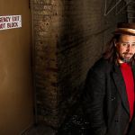 Musician Jason Webley looks around a gritty slice of old-Everett in the alley outside the Historic Everett Theatre, where he and other singer-songwriters will perform a concert Nov. 4 based on the Everett Massacre. The show, &ldquo;100 Years Ago Tomorrow,&rdquo; will feature original songs related to the labor strife that exploded in a gunfight on Everett&rsquo;s waterfront Nov. 5, 1916. (Dan Bates / The Herald)