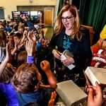 Last week, assistant principal, Carmen Boggs (center) passed out ice cream bars to Evergreen Middle School students who acquired library cards. Monday, this week, Boggs passed out ice cream bars to those kids and others who could name one thing you can do in a library besides check out books. &ldquo;I was shocked by how many kids didn&rsquo;t know what a library is,&rdquo; Boggs said. &ldquo;So I started this thing, and it has kind of grown from there.&rdquo; So far, she has given away 300 ice cream bars. Assisting Boggs, at right, is honorary assistant, Christopher Bakko, 13. (Dan Bates / The Herald)