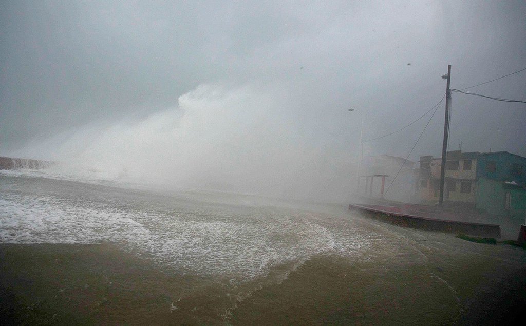 Surf and wind from Hurricane Matthew crash on the waterfront in Baracoa, Cuba, on Tuesday. The dangerous Category 4 storm blew ashore around dawn in Haiti. It unloaded heavy rain as it swirled on toward a lightly populated part of Cuba and the Bahamas. (AP Photo/Ramon Espinosa)