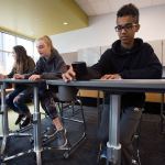 Leota Junior High eighth grader A.J. Springer places his cell phone in a grove in a stand-up/sit down desk as he and other students test out different chairs and desks at North Creek High School on Wednesday, Oct. 19, 2016 in Bothell, Wa. The students tested and graded three different sets of chairs and desks that the Northshore School District may purchase for the new high school. (Andy Bronson / The Herald)