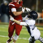 Snohomish&rsquo;s Keegan Stich (left) stiff-arms Arlington&rsquo;s Devon Nutter during a district play-in game Tuesday at Snohomish High School. (Ian Terry / The Herald)