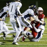Snohomish&rsquo;s Keegan Stich (right) is brought down by a swarm of Arlington defenders during a district play-in game Tuesday at Snohomish High School. (Ian Terry / The Herald)