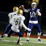 Meadowdale quarterback Drew Tingstad throws as he&rsquo;s pursued by a pair of Kelso defenders during a first round 3A state playoff game Friday at Edmonds Stadium. (Ian Terry / The Herald)