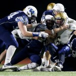 Kelso quarterback A.J. Hoggatt is brought down by Meadowdale defenders (from left) Levi Kowalski, Matthew Johnson and Markus Ward during the first half of a first round 3A state playoff game Friday at Edmonds Stadium. (Ian Terry / The Herald)