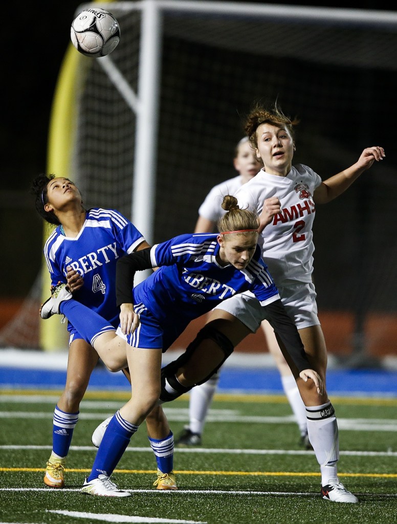 Liberty&rsquo;s Myka Carr (left) and Nikayla Copenhaver (center) jostle with Archbishop Murphy&rsquo;s Caroline Adams for a loose ball with Liberty&rsquo;s 6-2 win over the Wildcats in a 2A state semifinal on Friday in Shoreline. (Ian Terry / The Herald)