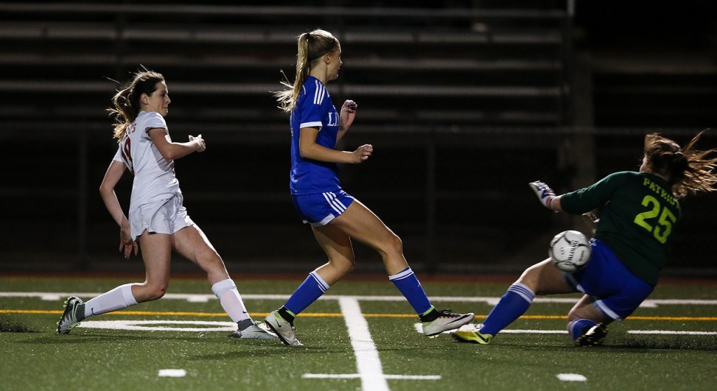 Archbishop Murphy&rsquo;s Lexie Klaudt (left) knocks a shot past Liberty goalkeeper Taylor Thatcher (right) for a goal in the second half of the Wildcats&rsquo; 6-2 loss to the Patriots in a 2A state semifinal on Friday at Shoreline Stadium. (Ian Terry / The Herald)