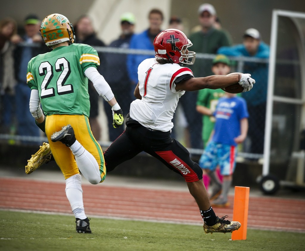 Archbishop Murphy&rsquo;s Kyler Gordon (1) reaches across the goal line for a touchdown as Tumwater&rsquo;s Jakob Holbrook (22) defends during a 2A state playoff game at Tumwater High School on Saturday. (Ian Terry / The Herald)