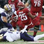 Washington State&rsquo;s Jamal Morrow fumbles the ball as Washington linebacker DJ Beavers recovers during the first quarter of the Apple Cup on Friday in Pullman. (Andy Bronson / The Herald)