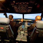 Jet Blue pilot, Capt. Joe Devito (left) navigates a NextGen flight simulator with FAA Administrator Michael Huerta at a Jet Blue facility in Orlando, Fla, in 2012.