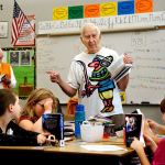 James Henry (back left) looks in one of the new dictionaries while Jack Lapoint (center) tells Silver Lake Elementary School third-graders in Christi Castro&rsquo;s class about some of the amazing information available in a dictionary, after the two Kiwanis Club members gave them new dictionaries. It was the final dictionary giveaway by the organization, which recently voted to disband because there aren&rsquo;t enough members. (Dan Bates / The Herald)